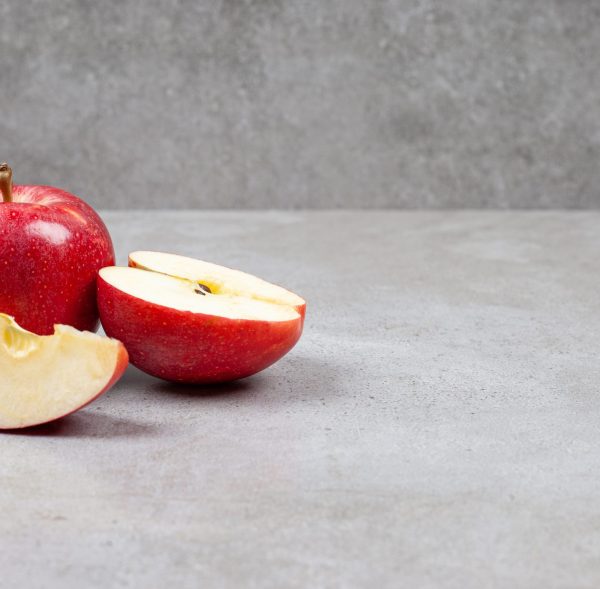 Fresh organic apples. Whole or sliced red apples on grey background. High quality photo